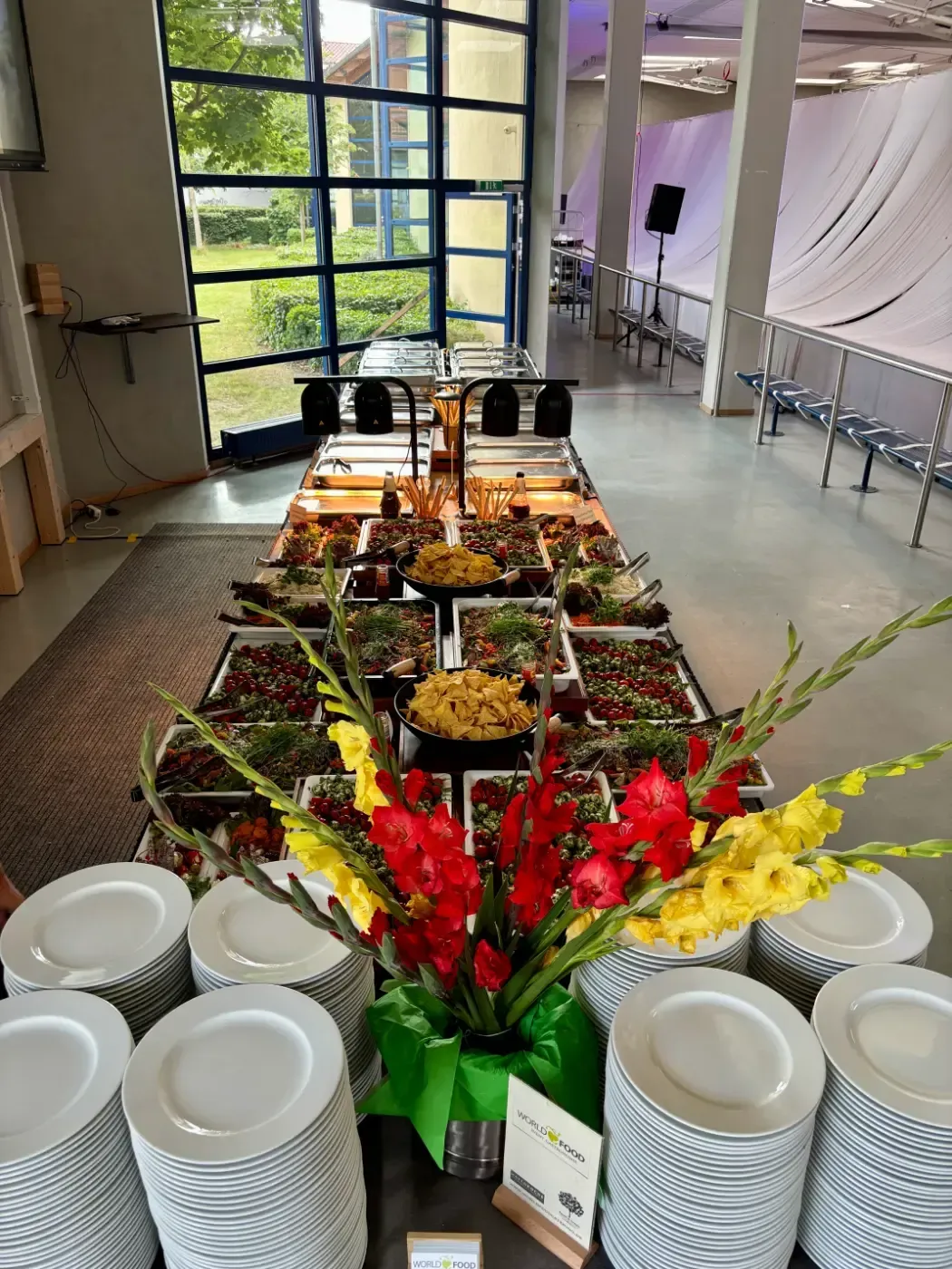 Ein langer Tisch mit Tellern und Blumen darauf