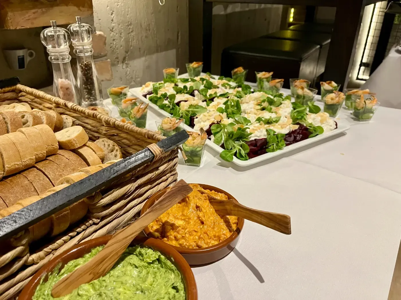 Ein Tisch mit Tellern voller Essen und Schüsseln mit Guacamole.