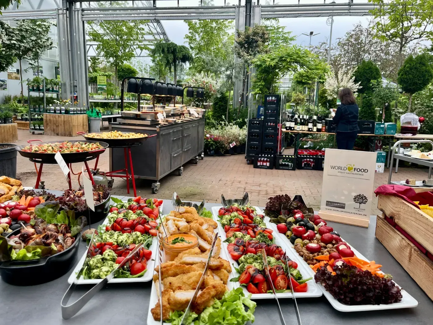Ein Buffettisch mit viel Essen in einem Gewächshaus.