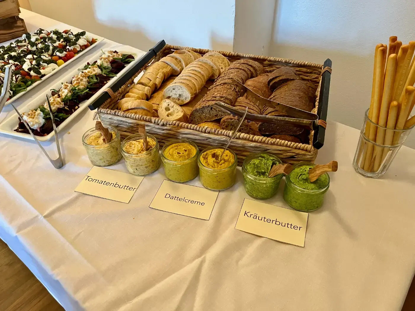 Ein Tisch mit einer Auswahl an Speisen, darunter Brot und Dips.