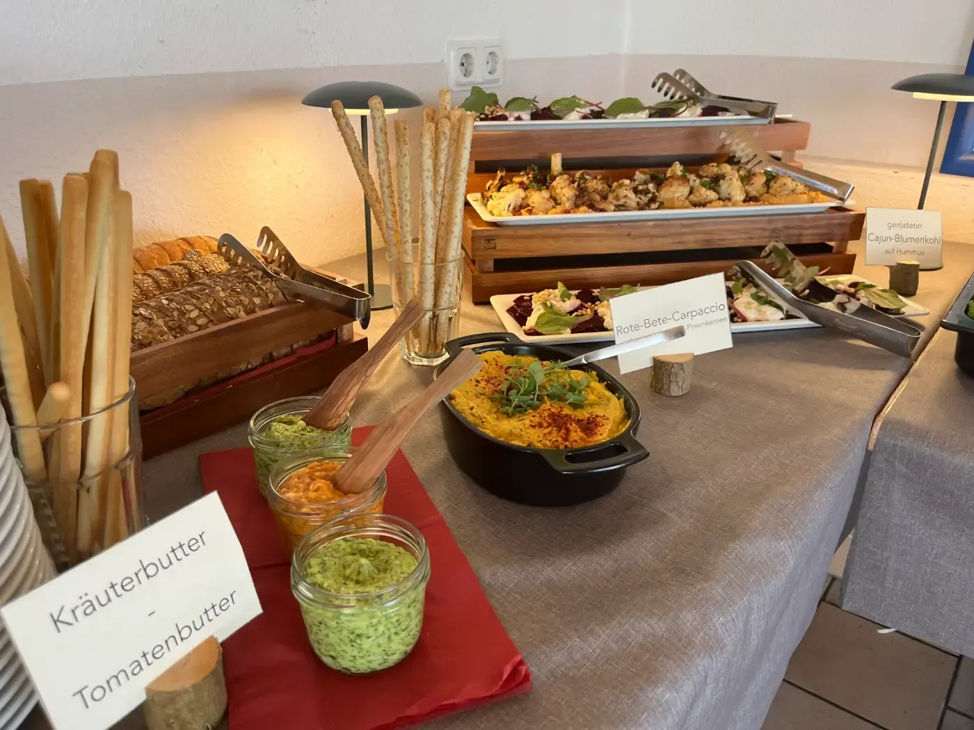 Ein Buffet-Tisch mit einem Schild mit der Aufschrift „Krauterbutter“ darauf