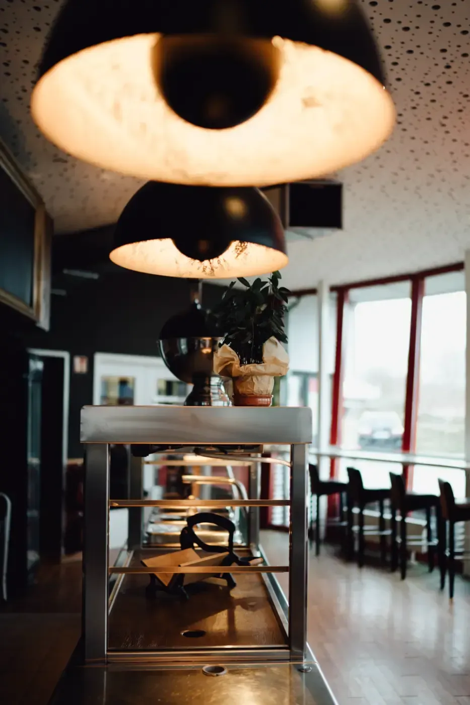 Ein Restaurant mit Tischen und Stühlen und einer Lampe, die von der Decke hängt.