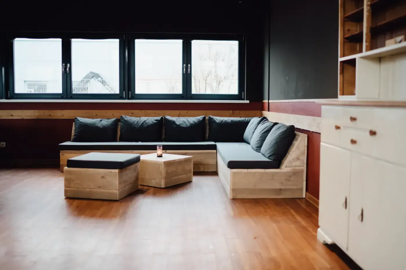 Ein Wohnzimmer mit Sofa, Ottomane und Tisch.