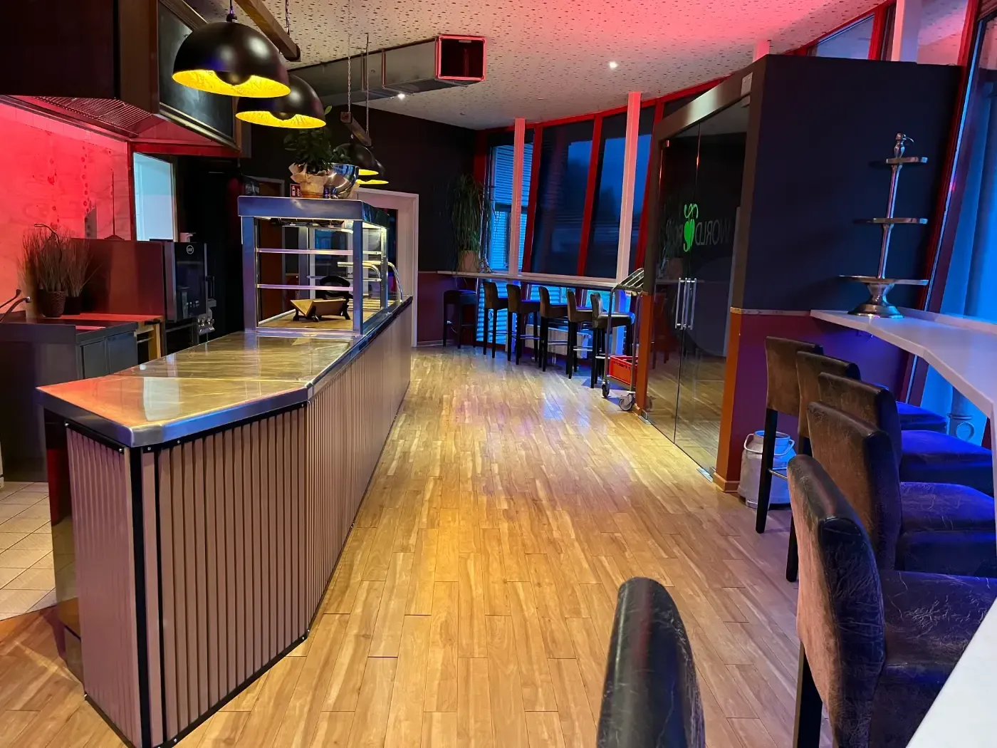 Ein Restaurant mit Holzboden und einer langen Theke.