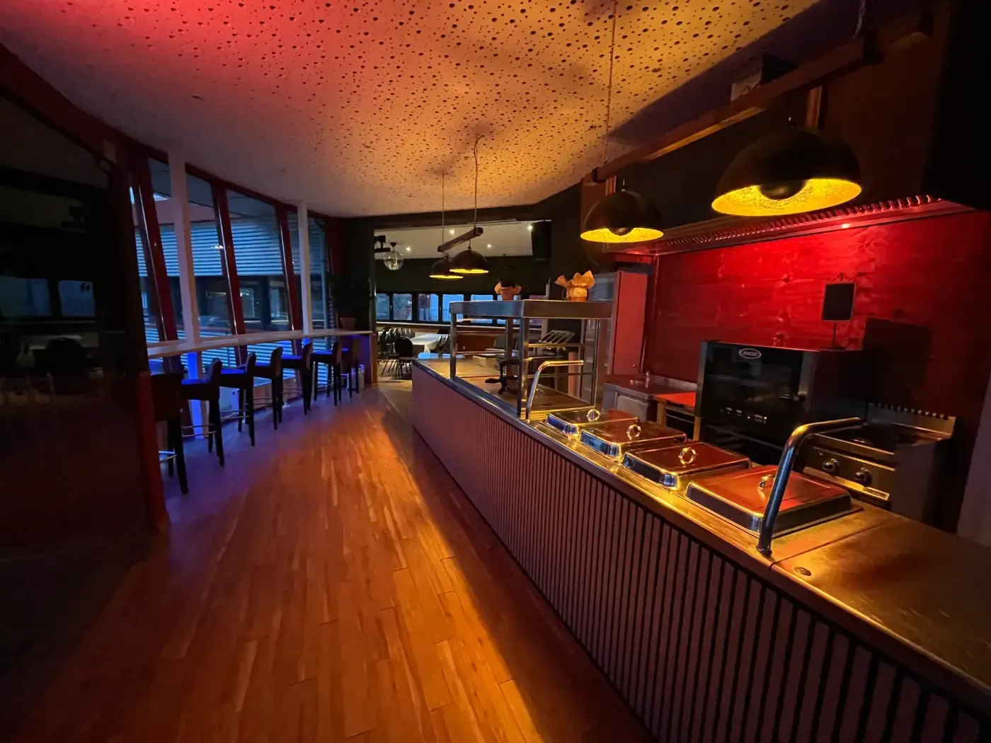 Eine lange Theke in einem Restaurant mit einer roten Wand