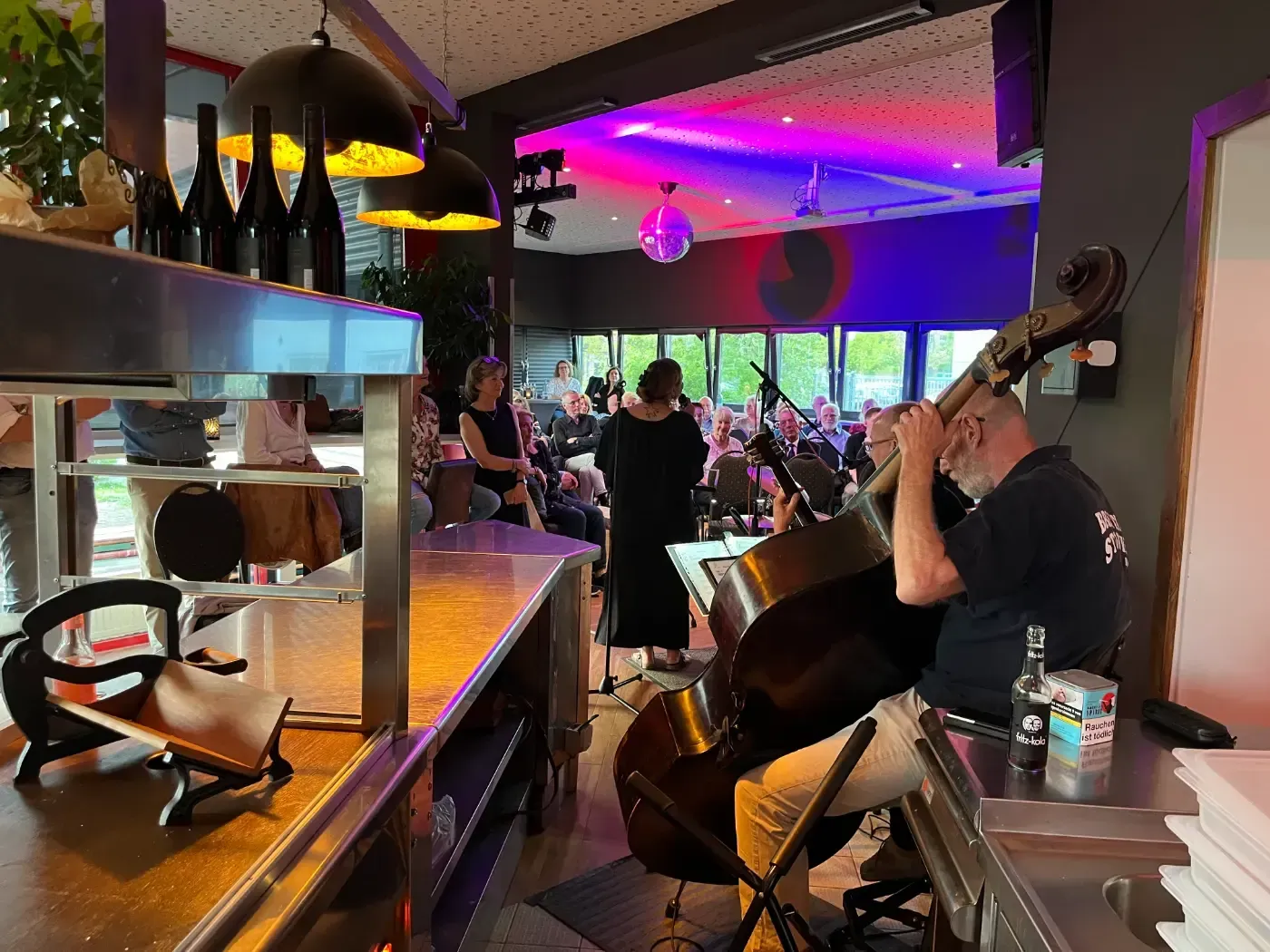 Ein Mann spielt in einem Restaurant Kontrabass.