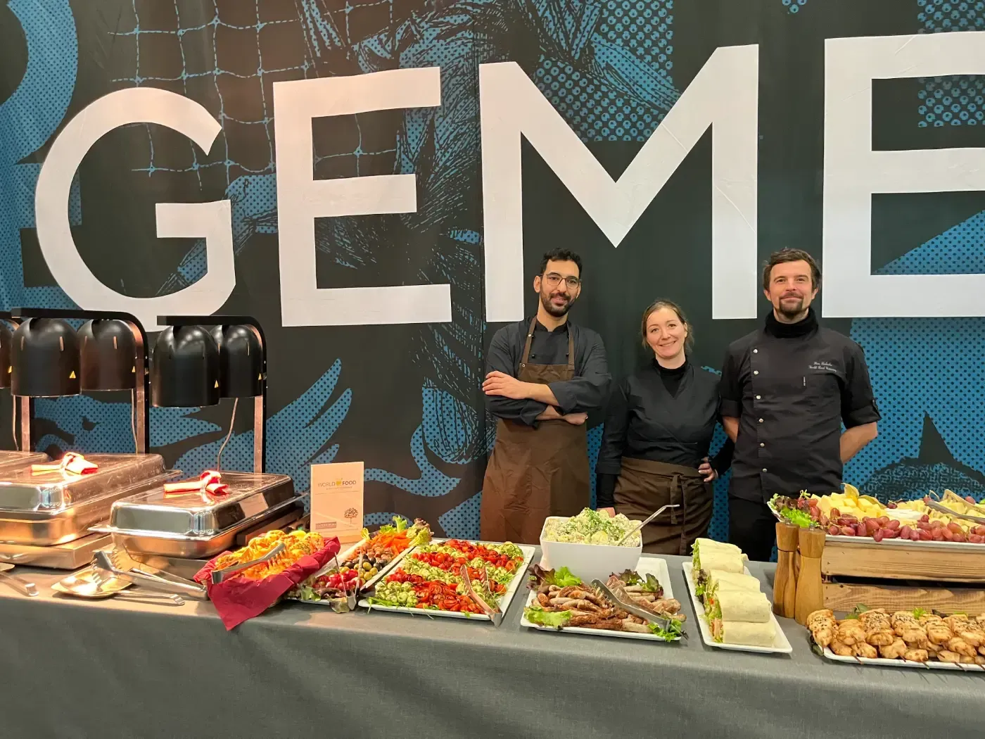 Eine Gruppe von Menschen steht vor einem Buffettisch.