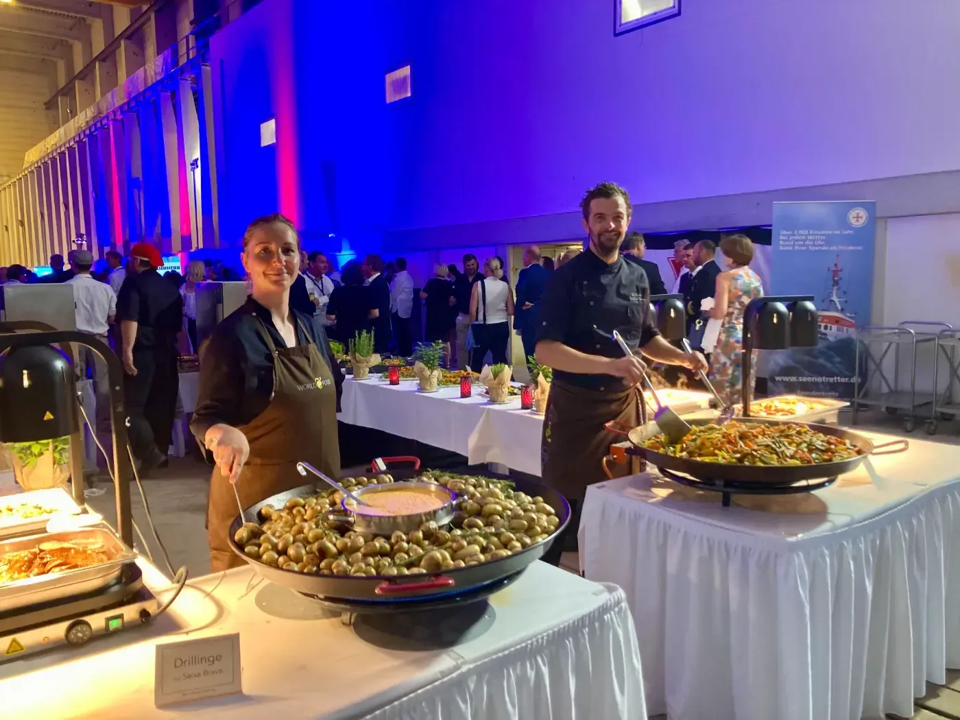 Ein Mann und eine Frau stehen vor einem Buffettisch.