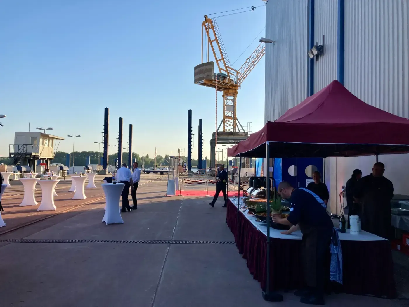 Ein Mann steht an einem Tisch vor einem roten Zelt.