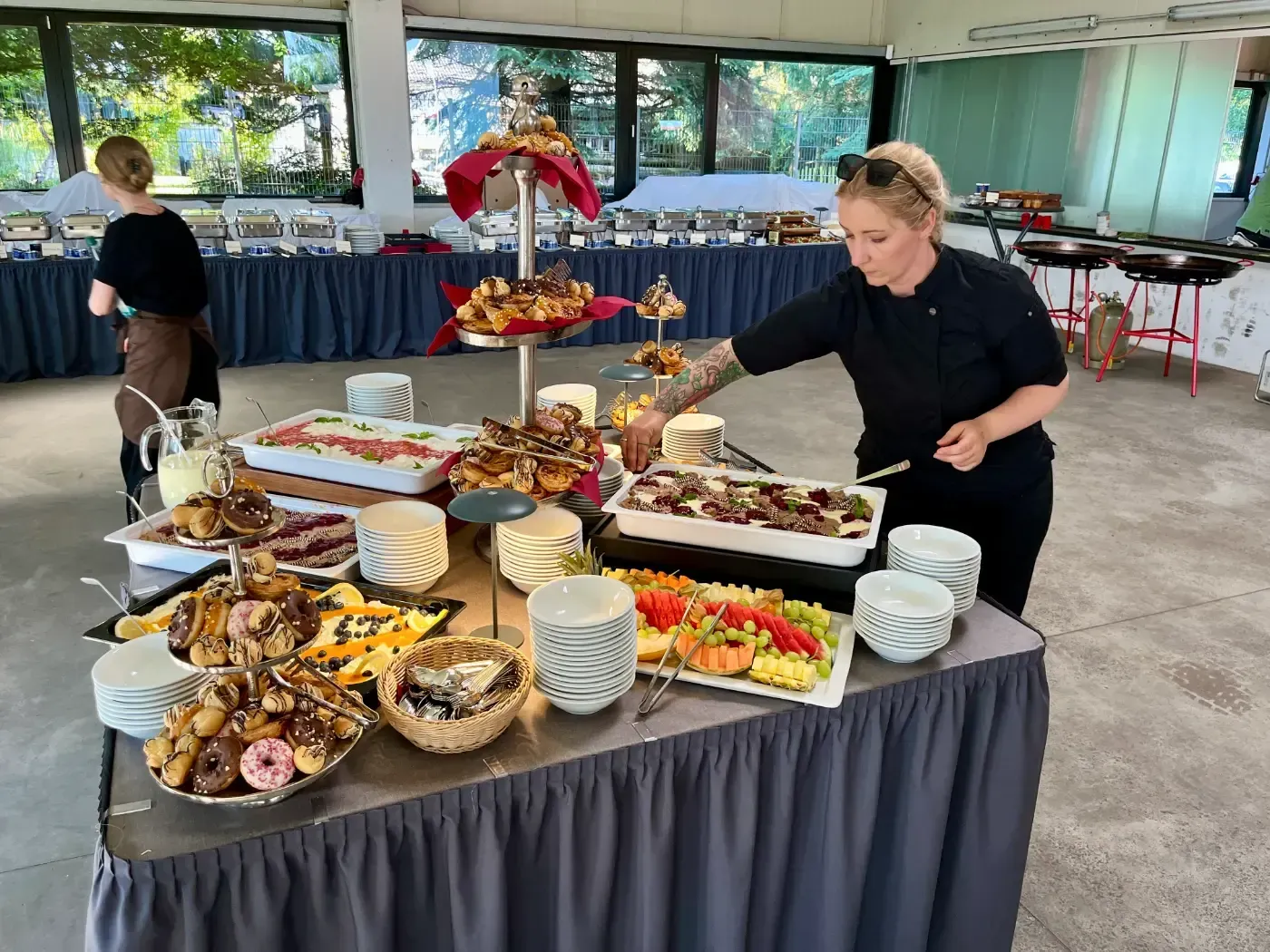 Eine Frau steht vor einem mit Essen gefüllten Buffettisch.