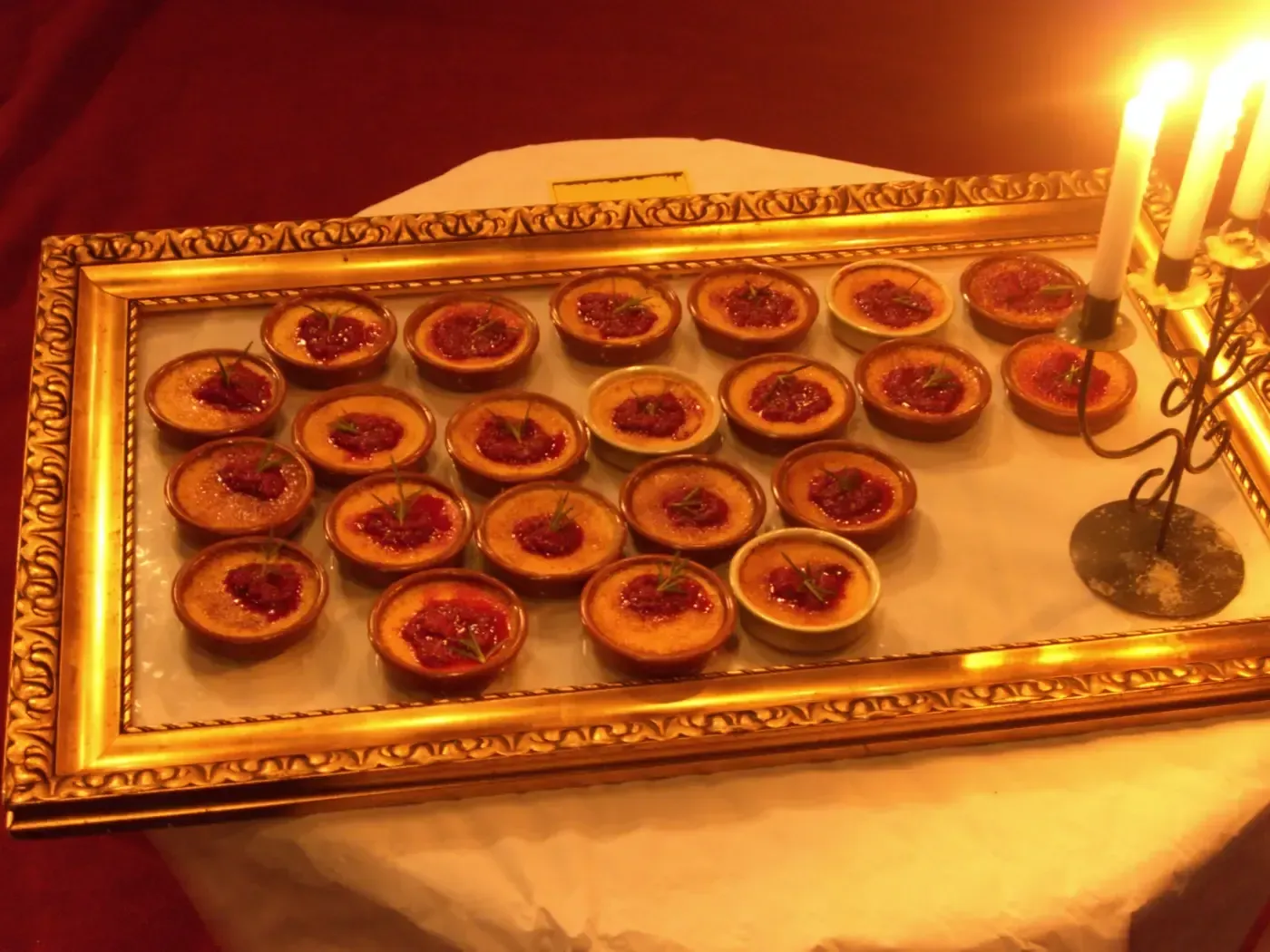 Ein Bilderrahmen gefüllt mit Cupcakes und Kerzen auf einem Tisch