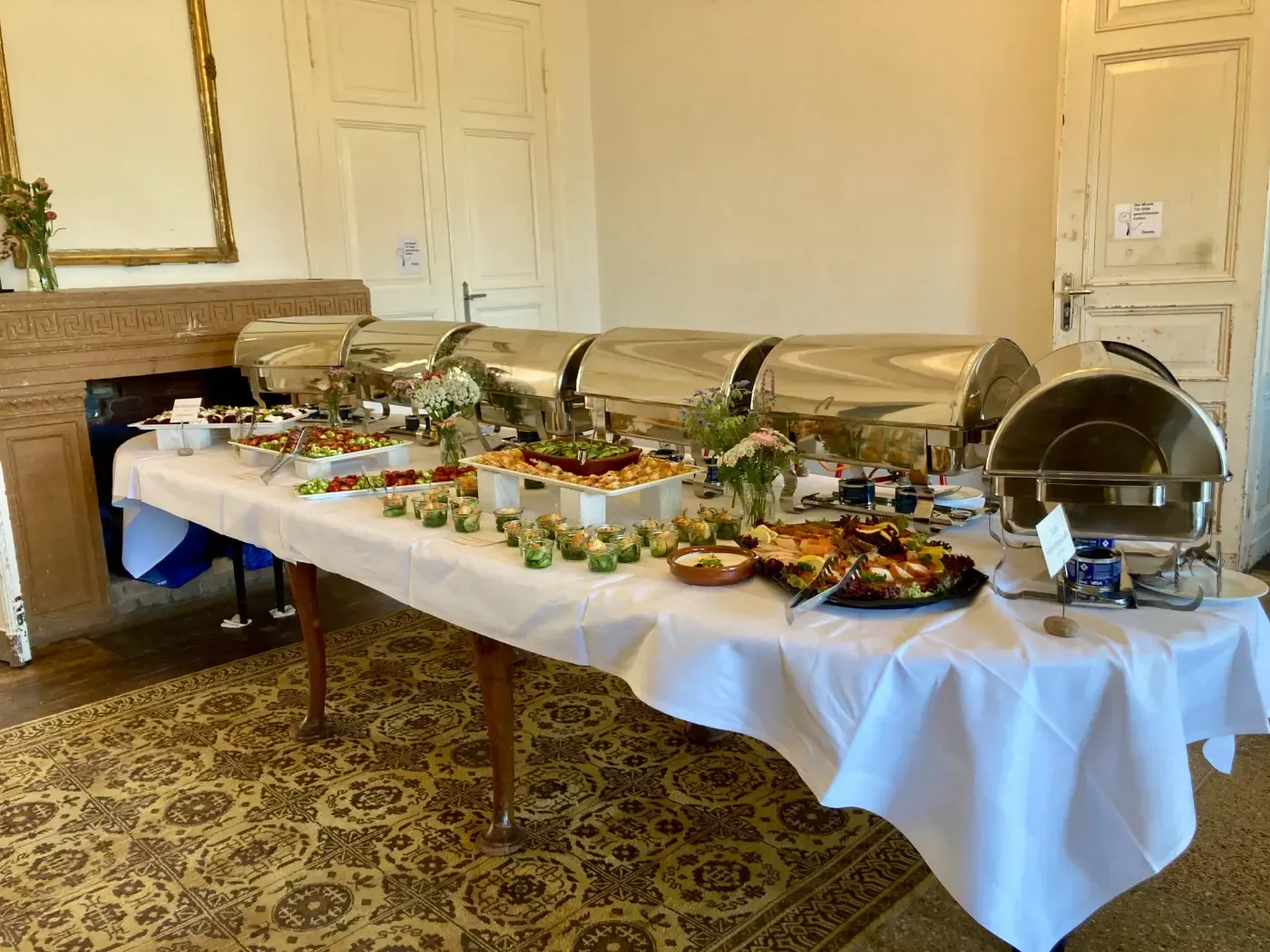 Ein langer Tisch mit viel Essen darauf in einem Raum.