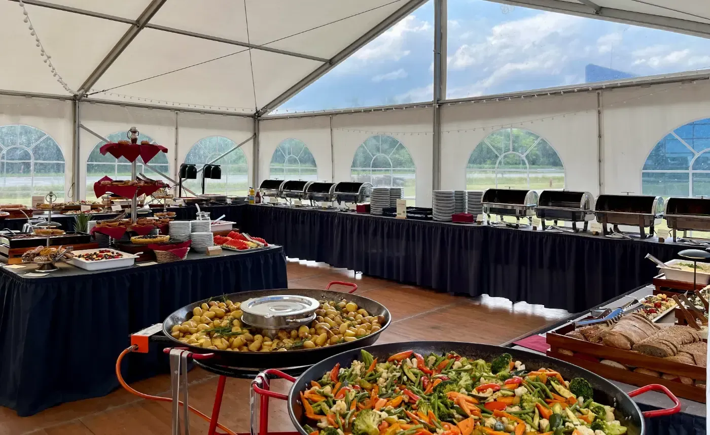 Ein großes Zelt mit viel Essen und Buffet-Tischen.