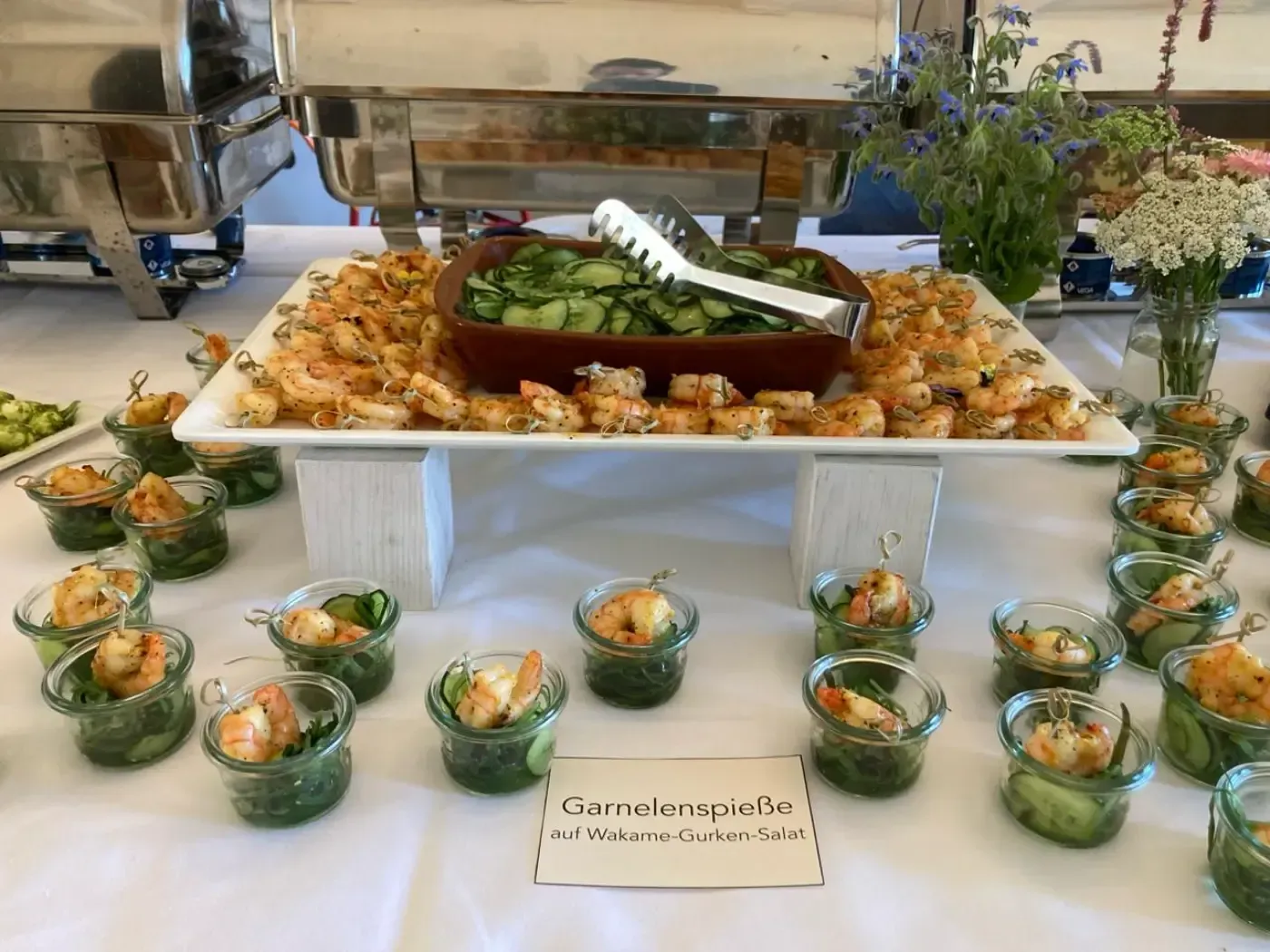 Ein Buffettisch mit Garnelen- und Gurkenhäppchen.