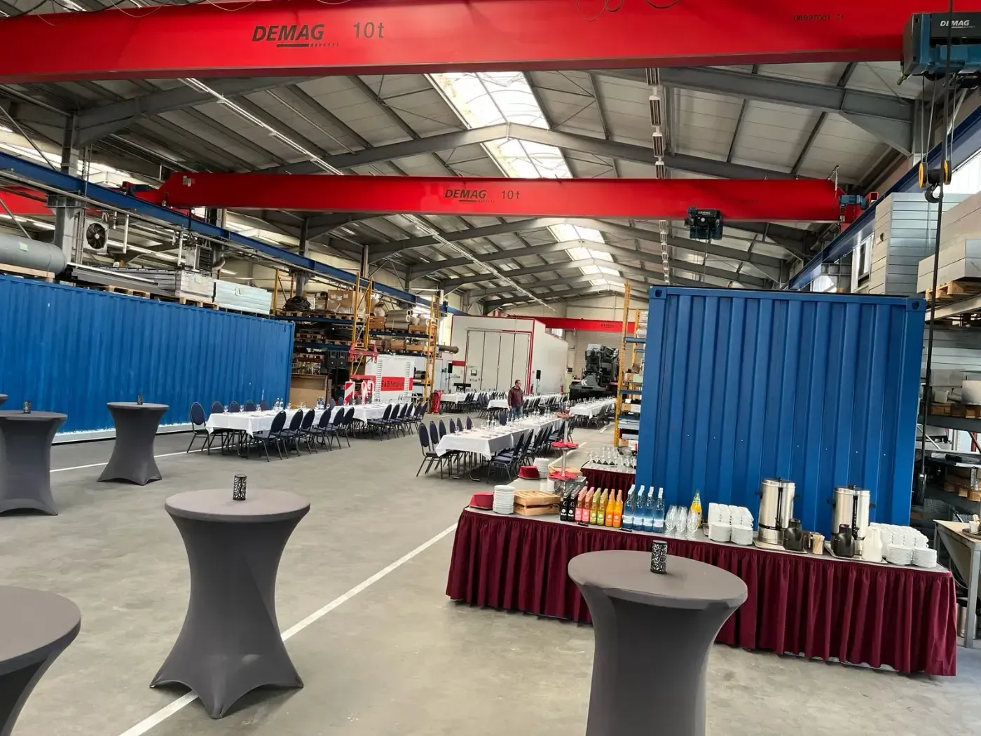 Ein großes Lagerhaus voller Tische und Stühle und einem Kran.