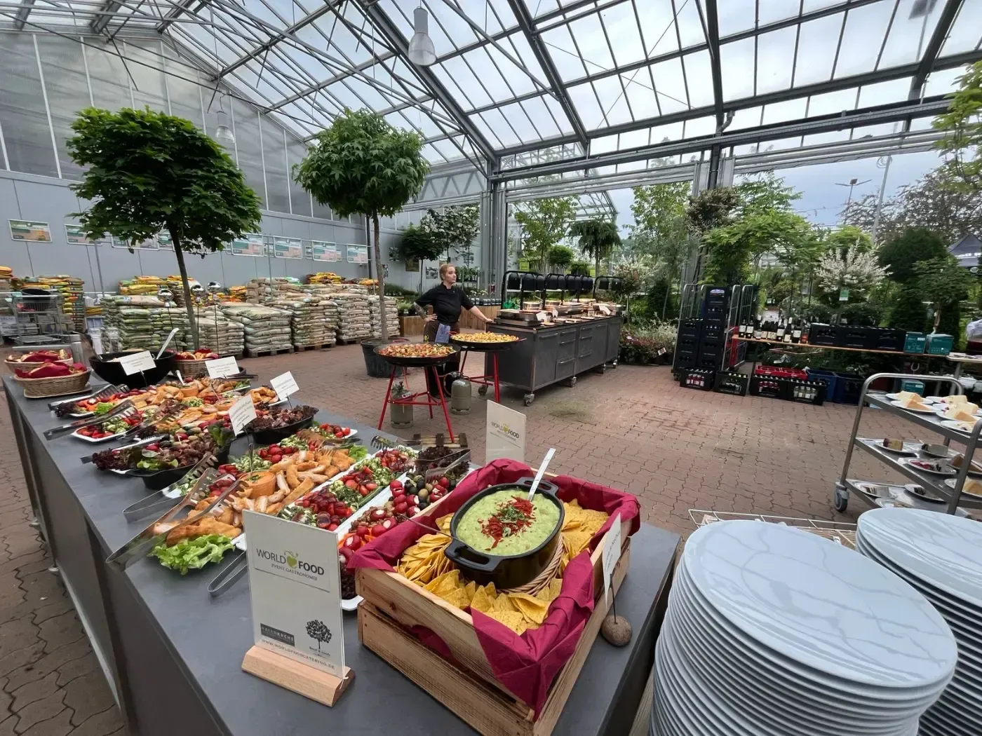 Ein Buffettisch in einem Gewächshaus, gefüllt mit viel Essen.