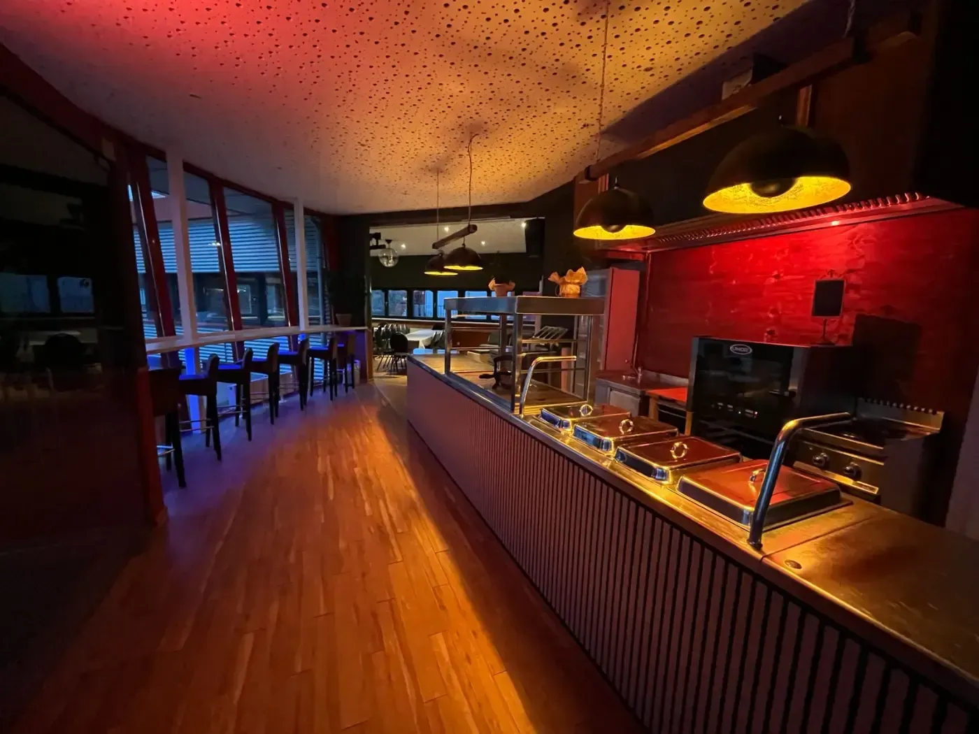 Eine lange Theke in einem Restaurant mit roten Lichtern an der Decke.