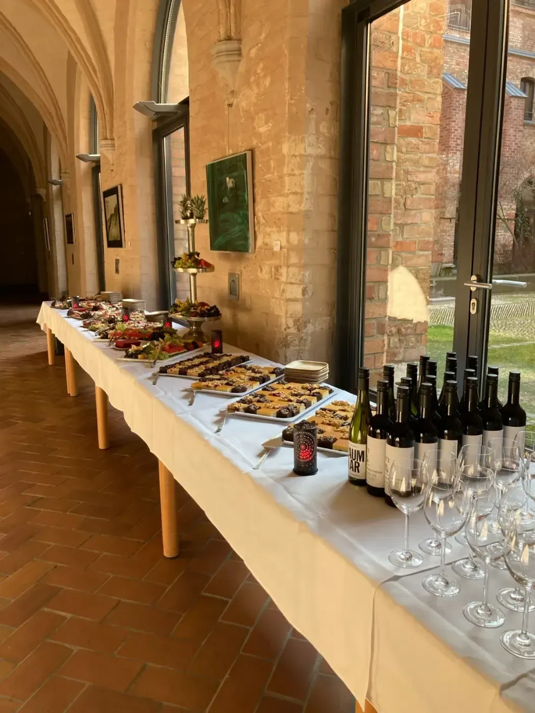 Ein langer Tisch mit Weinflaschen und Gläsern darauf.