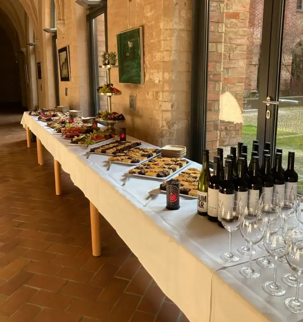 Ein langer Tisch voller Essen und Weinflaschen