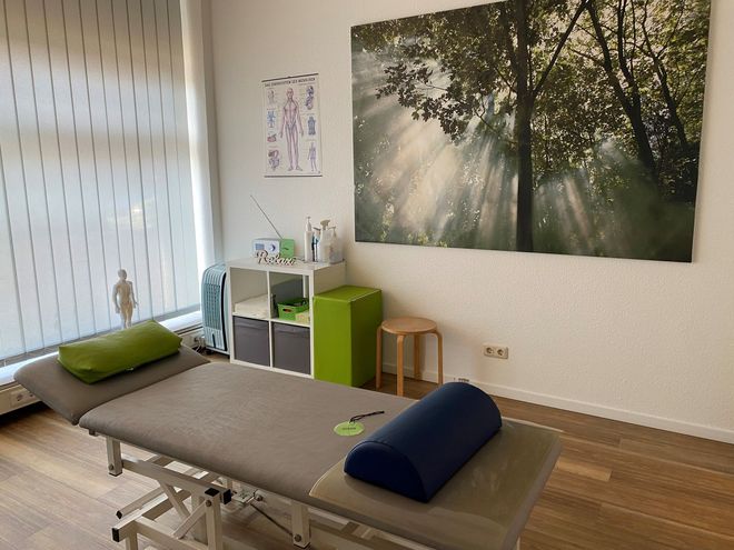 Praxisraum mit Liege, Regal und einem Bild an der Wand