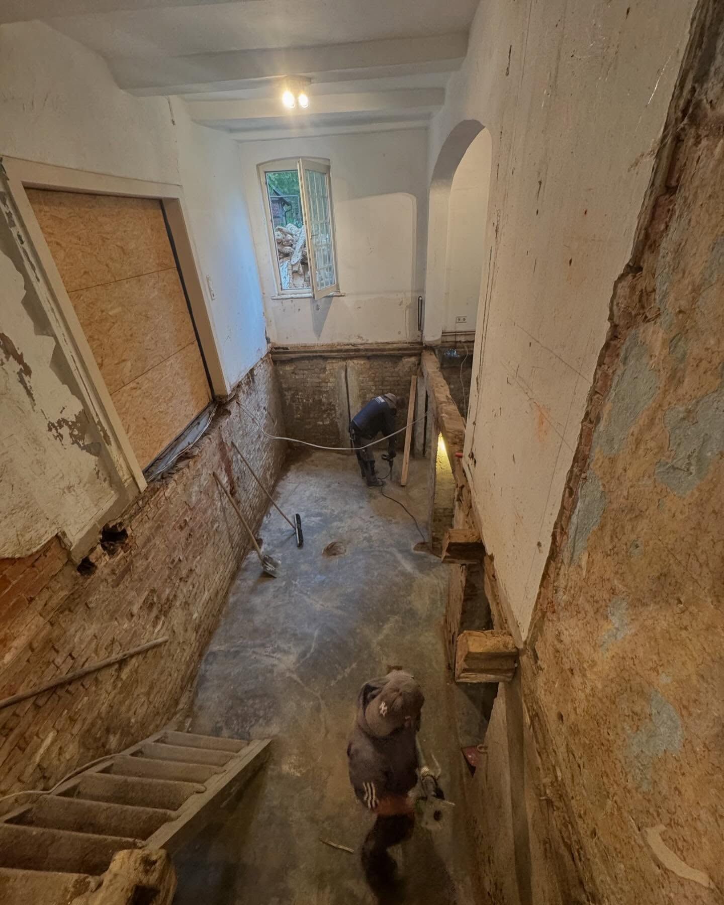 Ein Mann steht in einem Raum mit Treppe und Fenster.