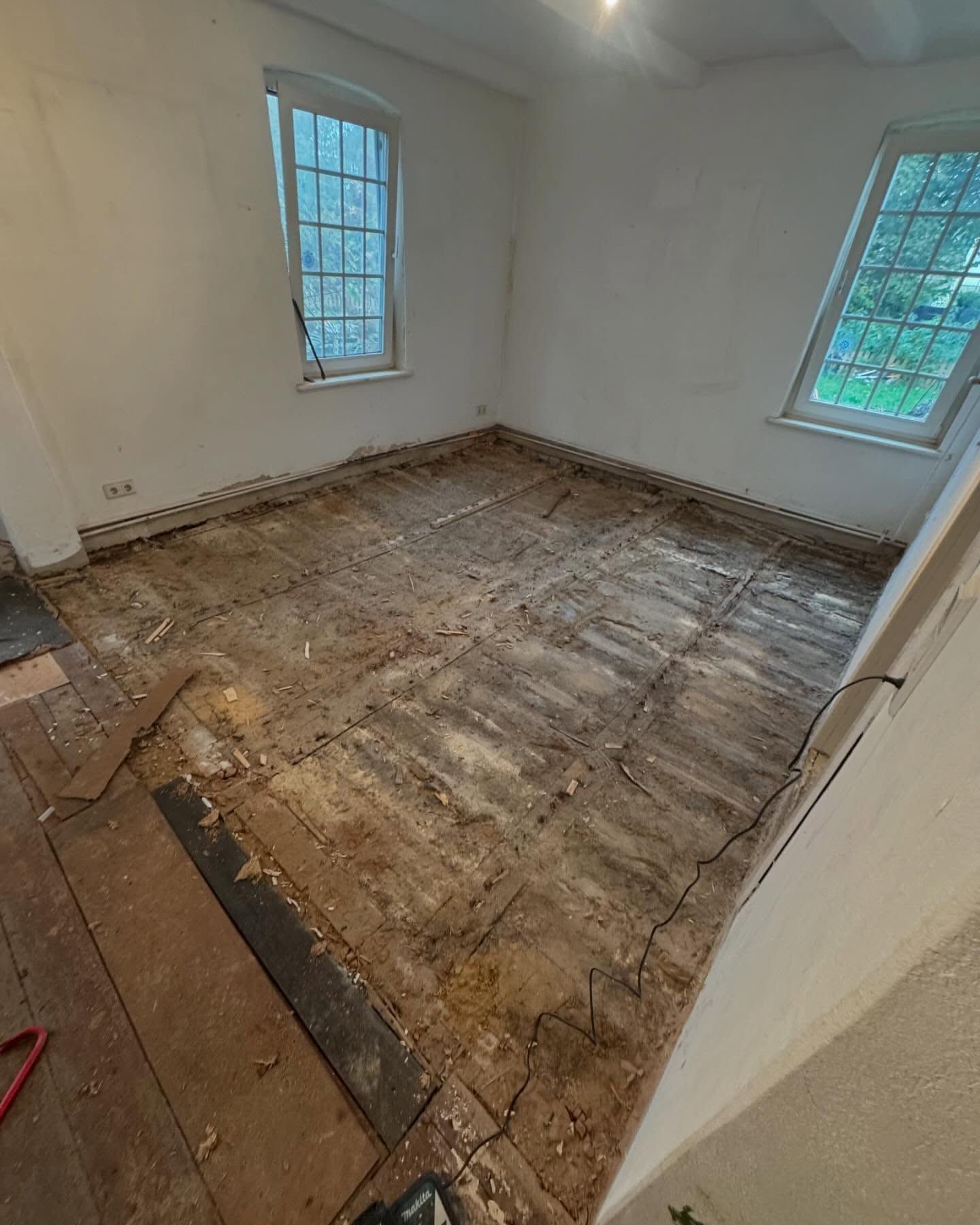 Ein Raum mit Holzboden und Fenster.