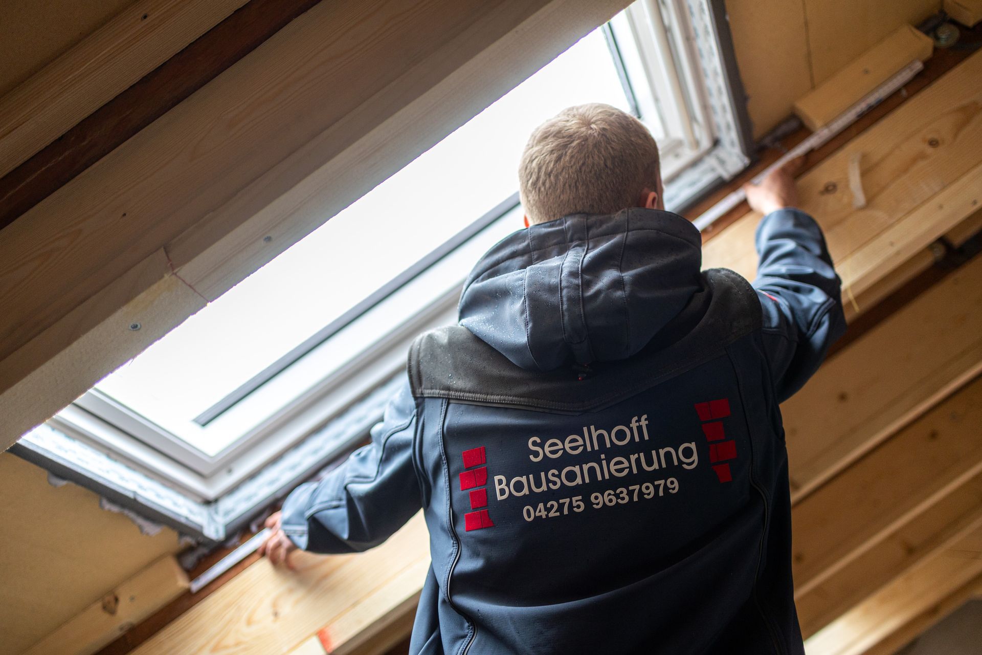 Ein Mann schaut aus einem Oberlicht in einem Gebäude.