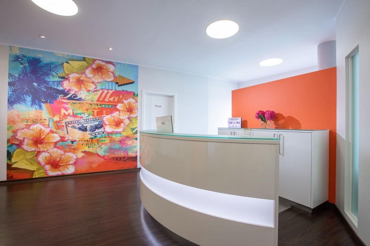 Eine Rezeption mit einem farbenfrohen Wandgemälde an der Wand dahinter.