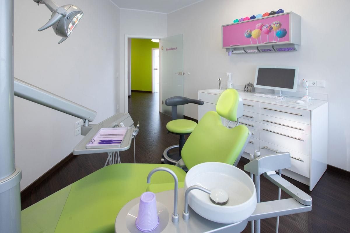 Eine Zahnarztpraxis mit einem grünen Stuhl und einem Waschbecken