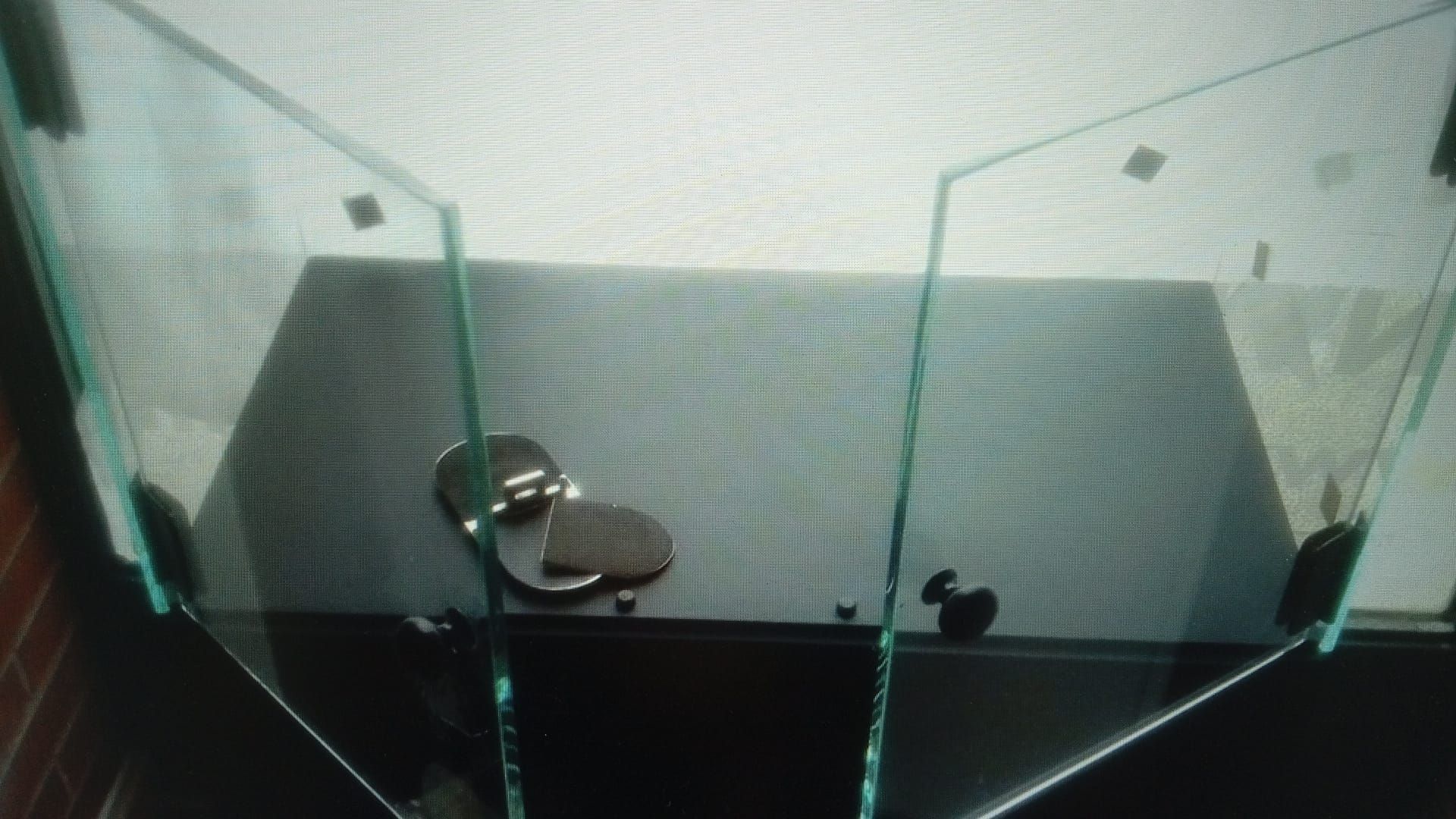 Puerta de cristal con tirador metálico, colocada en un marco oscuro.