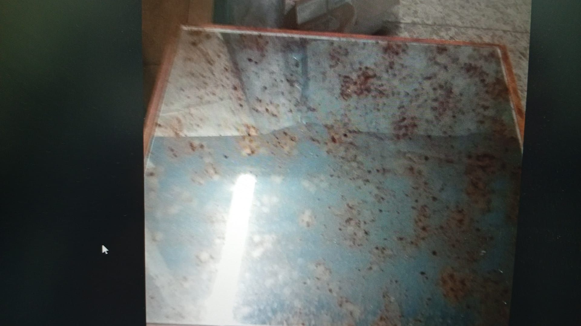 Superficie metálica azul y cubierta de óxido, posiblemente parte de una máquina, con desgaste y decoloración.