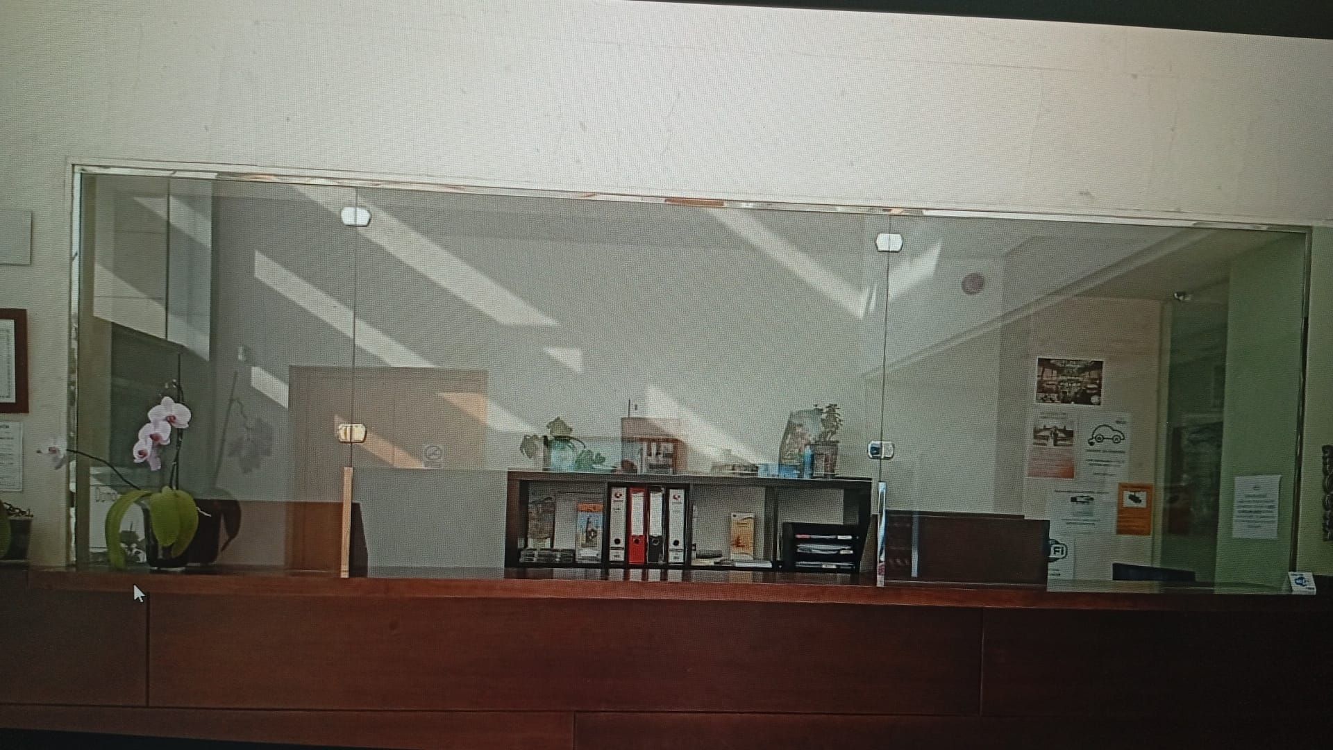 Mostrador de recepción con barrera transparente, en el interior.