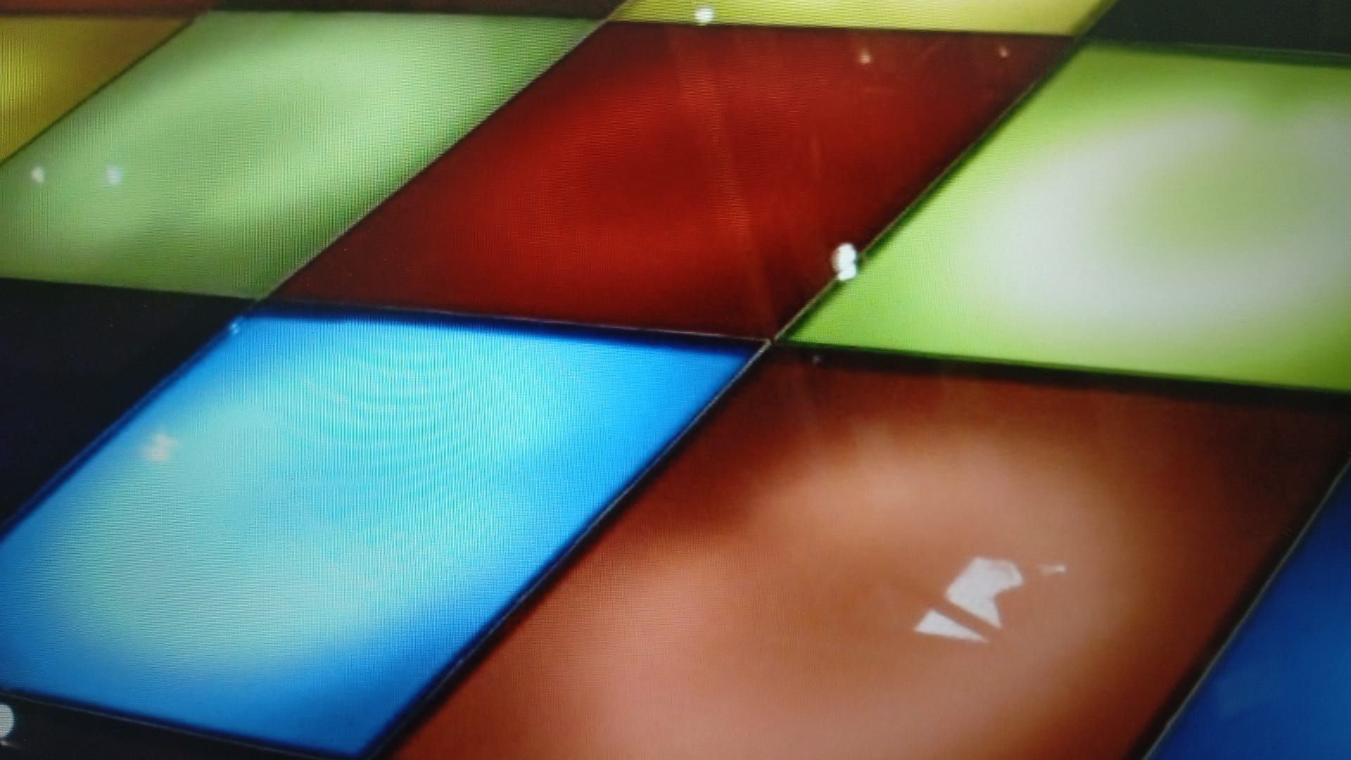 Pista de baile con baldosas coloridas e iluminadas en rojo, azul, verde y naranja.