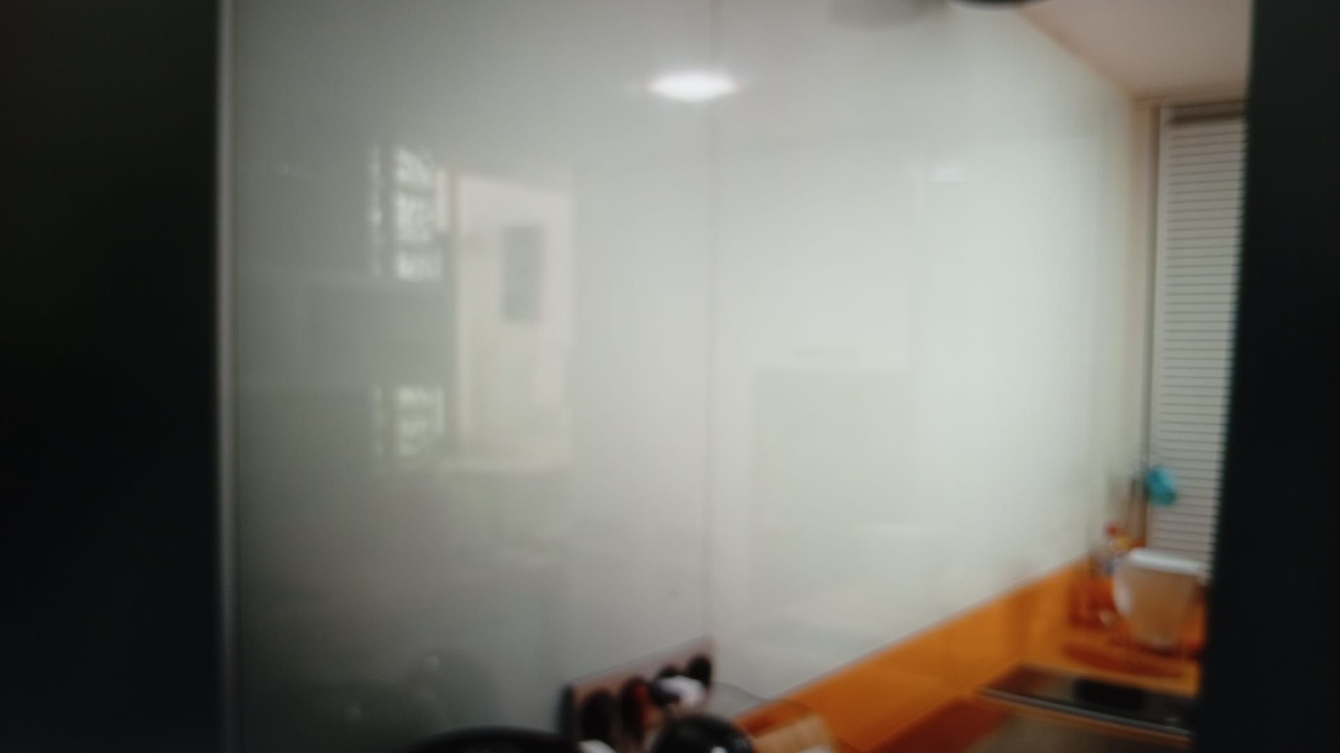 Pared de baño con azulejos blancos, lavabo y ventana.