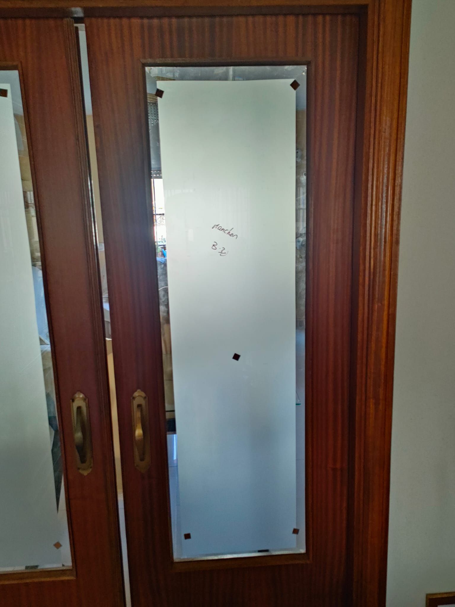 Puertas dobles de madera con paneles de vidrio esmerilado.