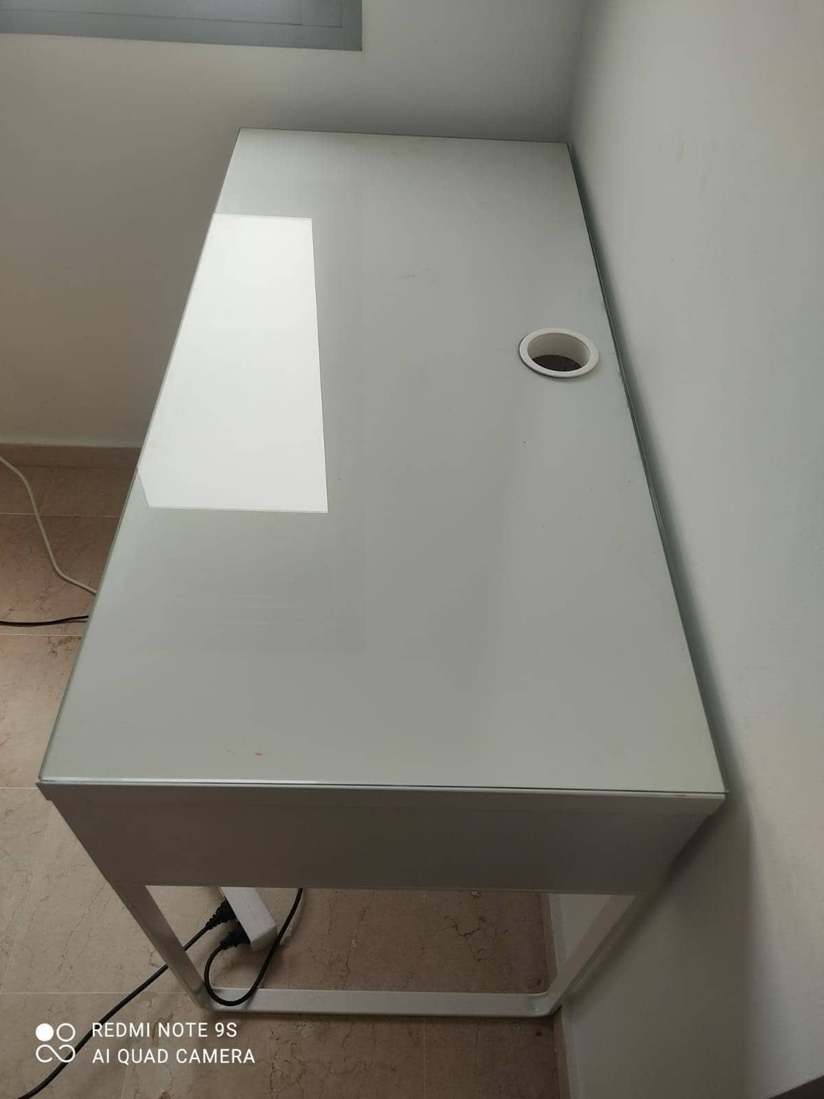 Obreros de la construcción dentro de un apartamento con andamios, herramientas y grandes ventanales; tonos neutros.