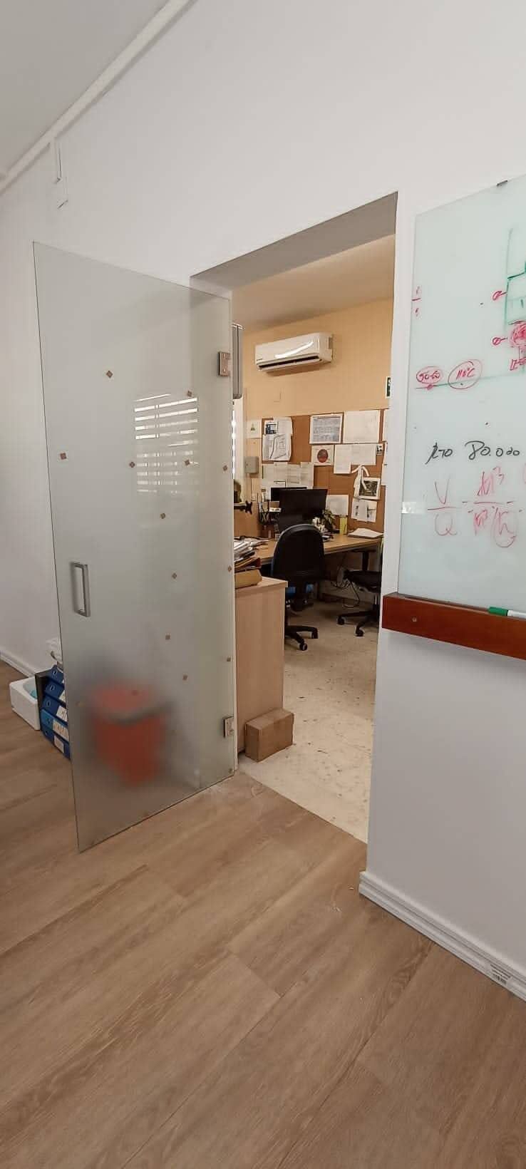 Persona que utiliza una paleta para aplicar mortero a una pared de ladrillos rojos.
