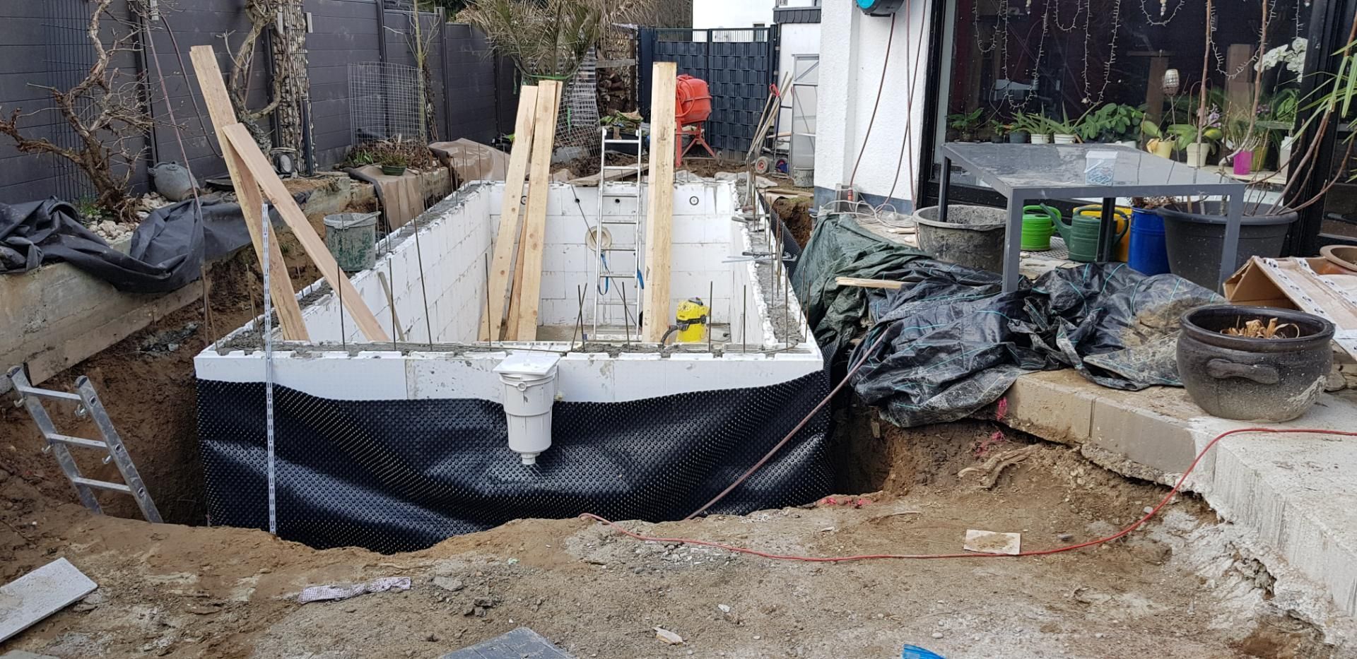 Im Garten befindet sich eine rechteckige, im Boden eingelassene Struktur, möglicherweise ein Pool, die sich im Bau befindet.