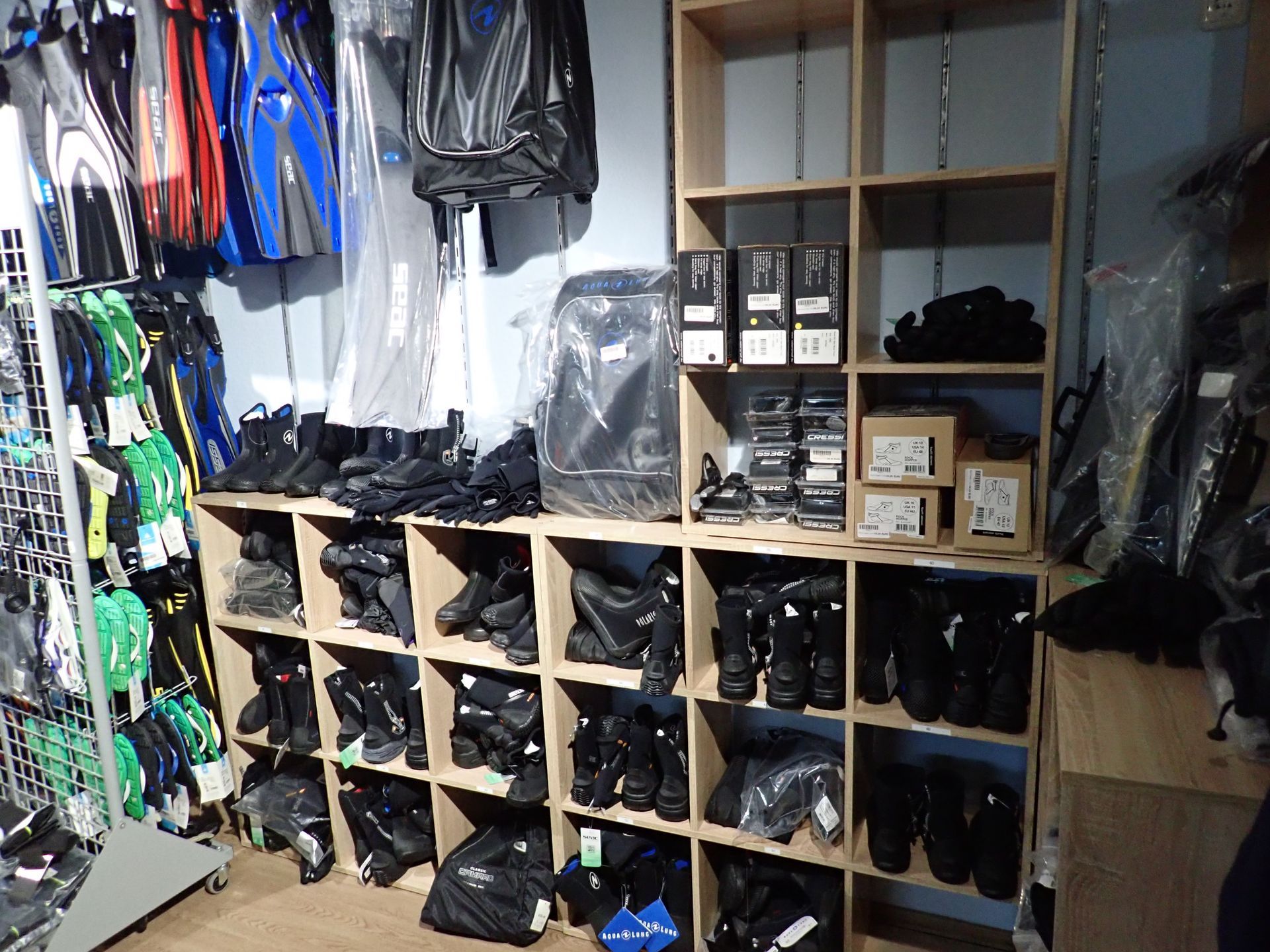 Regale mit Tauchausrüstung: Stiefel, Flossen, Masken und Taschen in einem Einzelhandelsgeschäft.