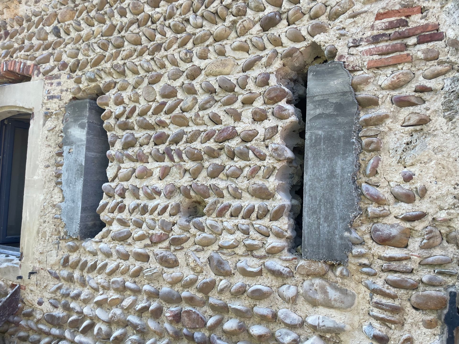Mur en pierres avec fenêtres et volets