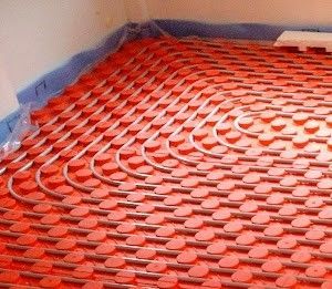 Un primer plano de un sistema de calefacción por suelo radiante rojo en una habitación.