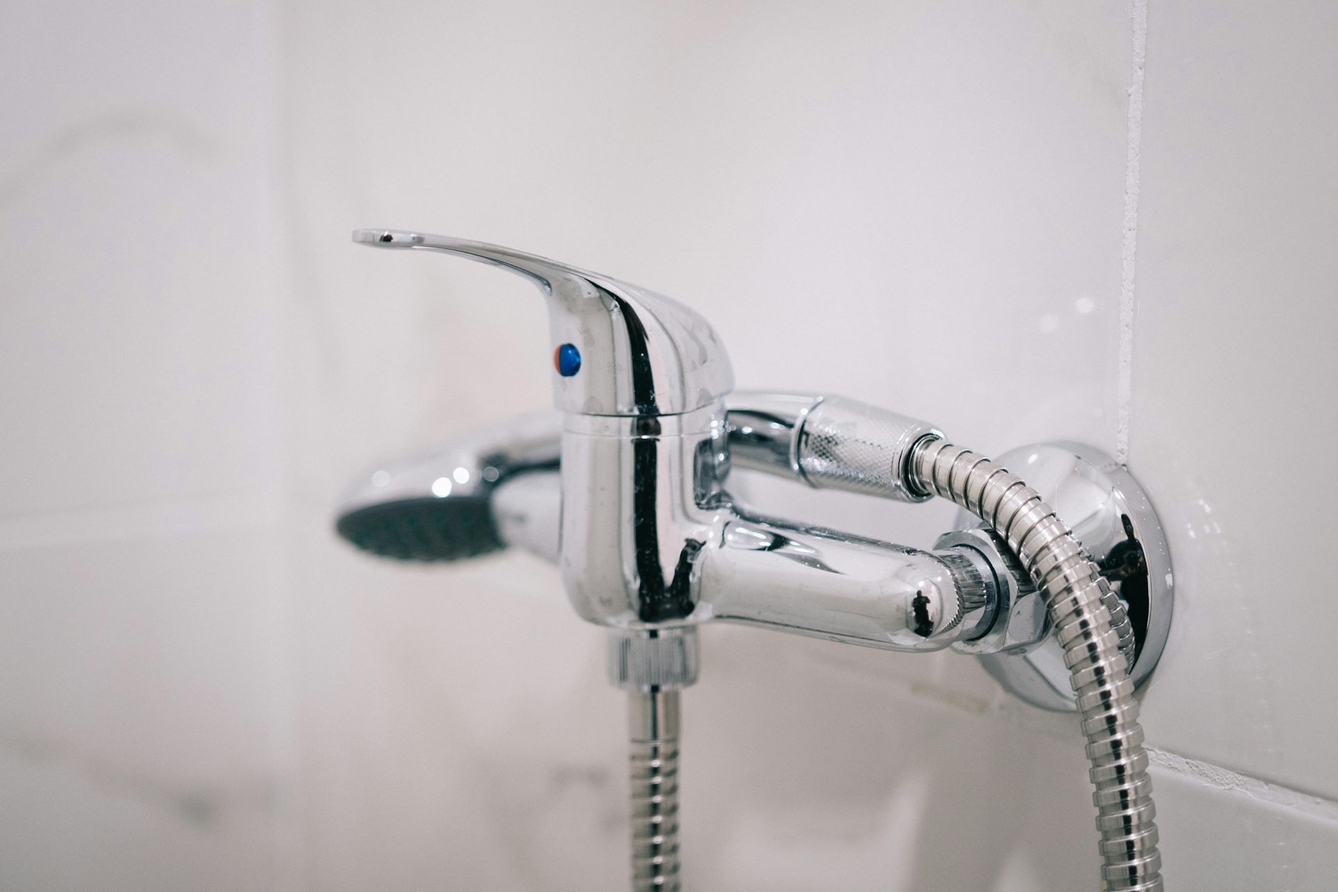 Un primer plano de un cabezal de ducha y un grifo en un baño.