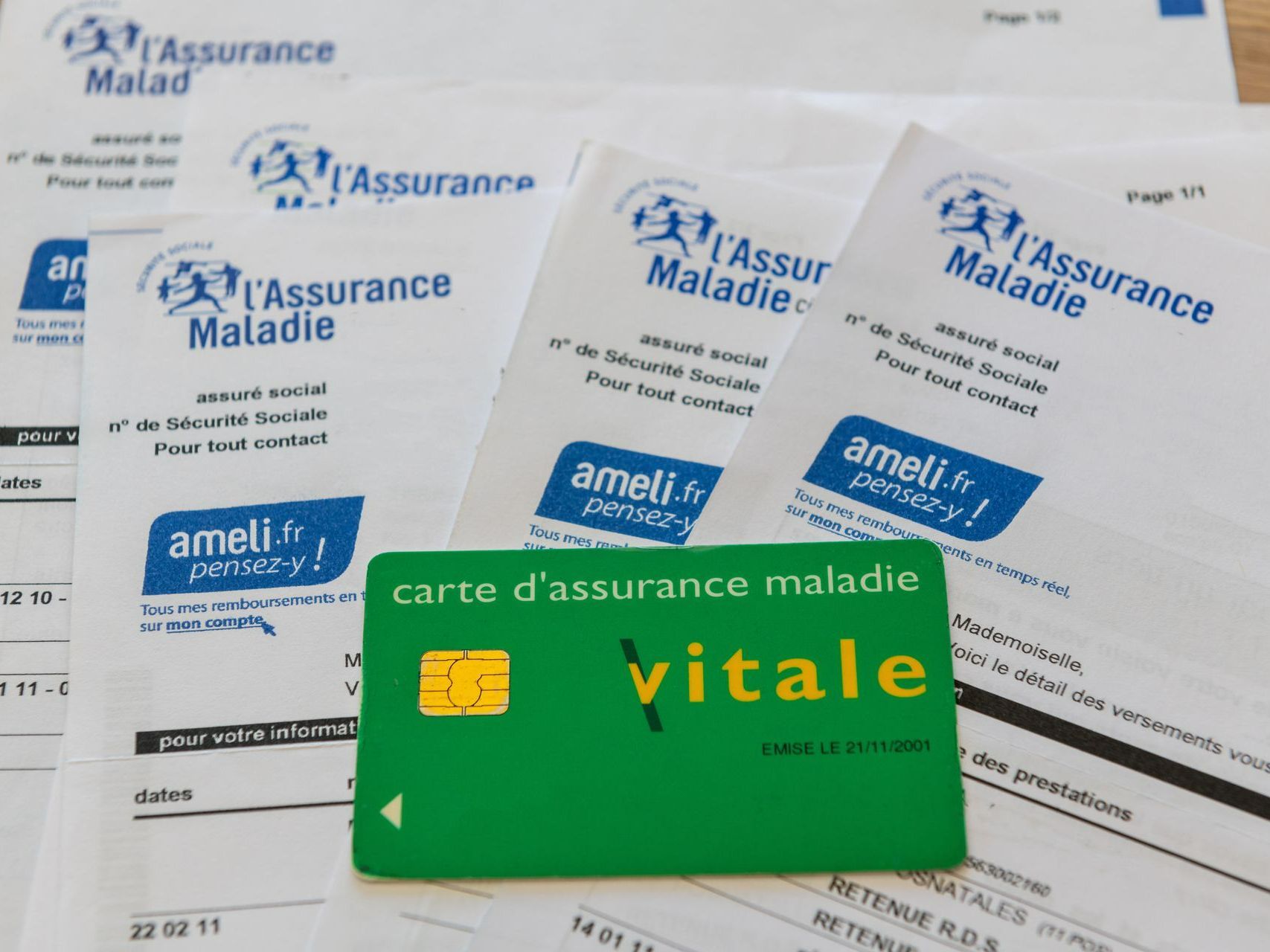 Carte Vitale posée sur les documents de l'Assurance Maladie.