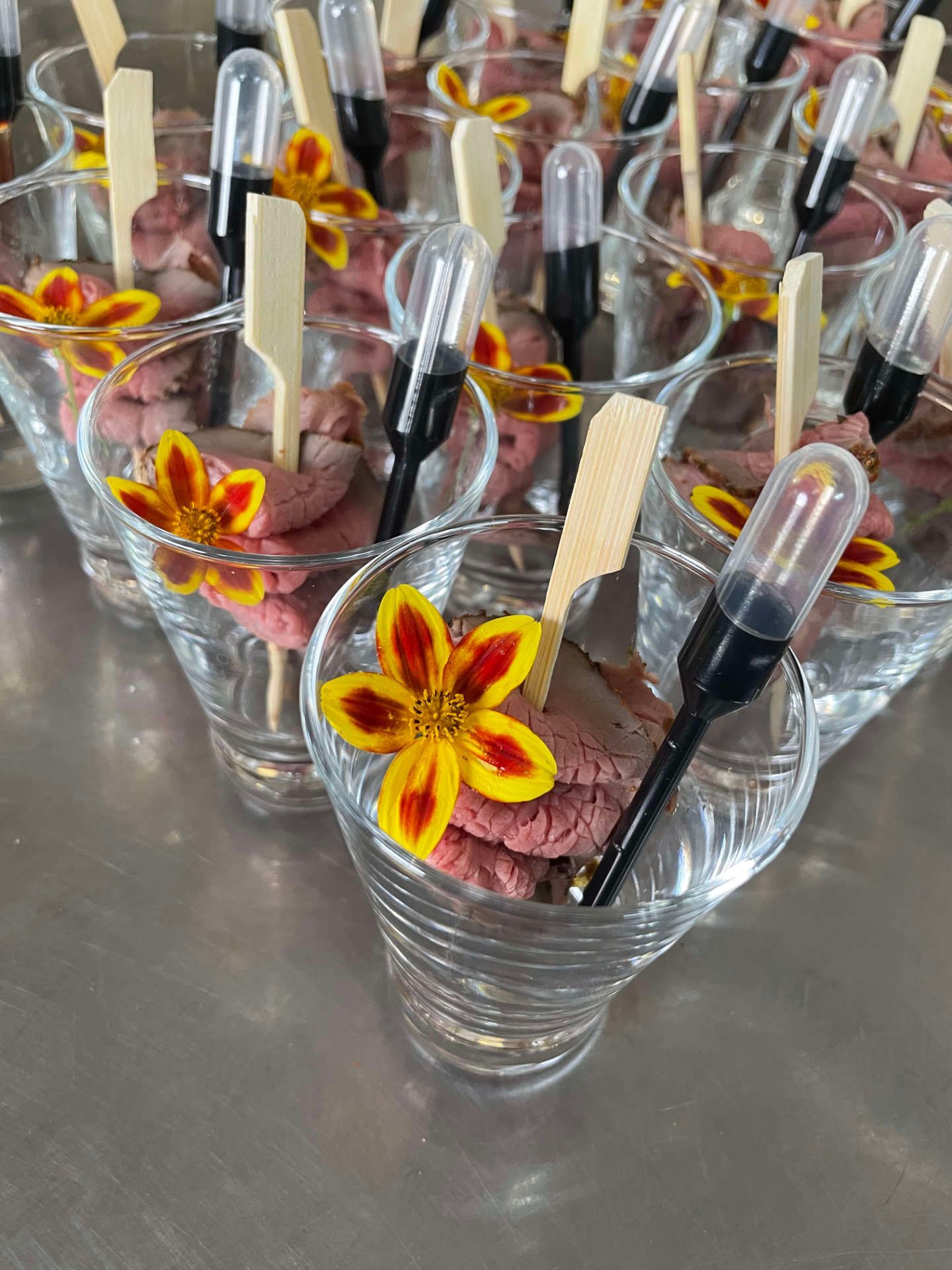 Eine Reihe von Martinigläsern gefüllt mit Essen und Blumen.