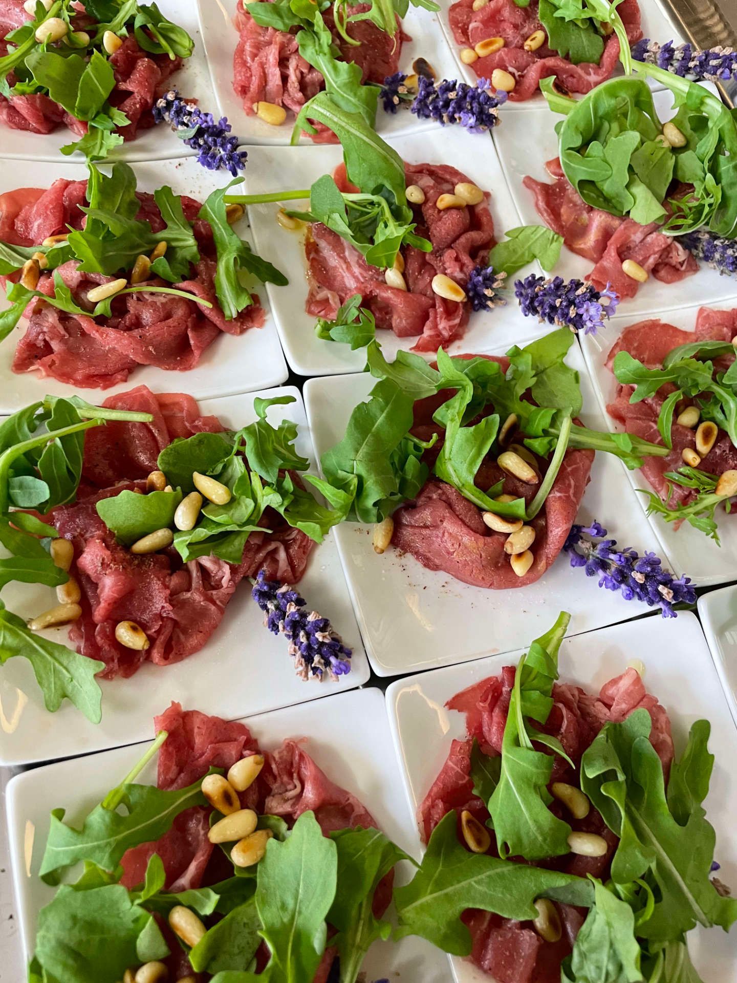 Mehrere Teller mit Fleisch und Gemüse stehen auf einem Tisch.