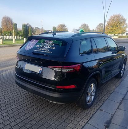 Un taxi noir sur le parvis d'un cimetière américain