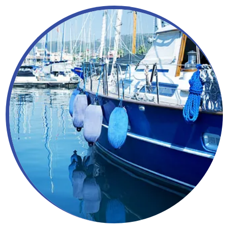 Un barco azul está atracado en un puerto con muchos otros barcos.