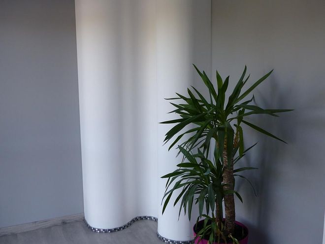 Pièce avec parquet, fenêtres le long du mur et plaques de plâtre sur le mur.