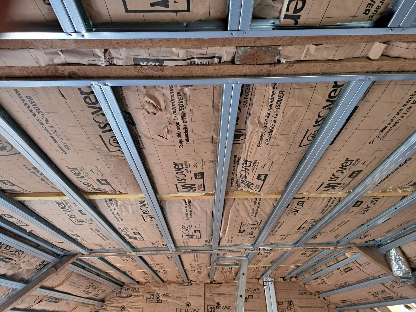 Plafond en construction avec ossature métallique et isolation.