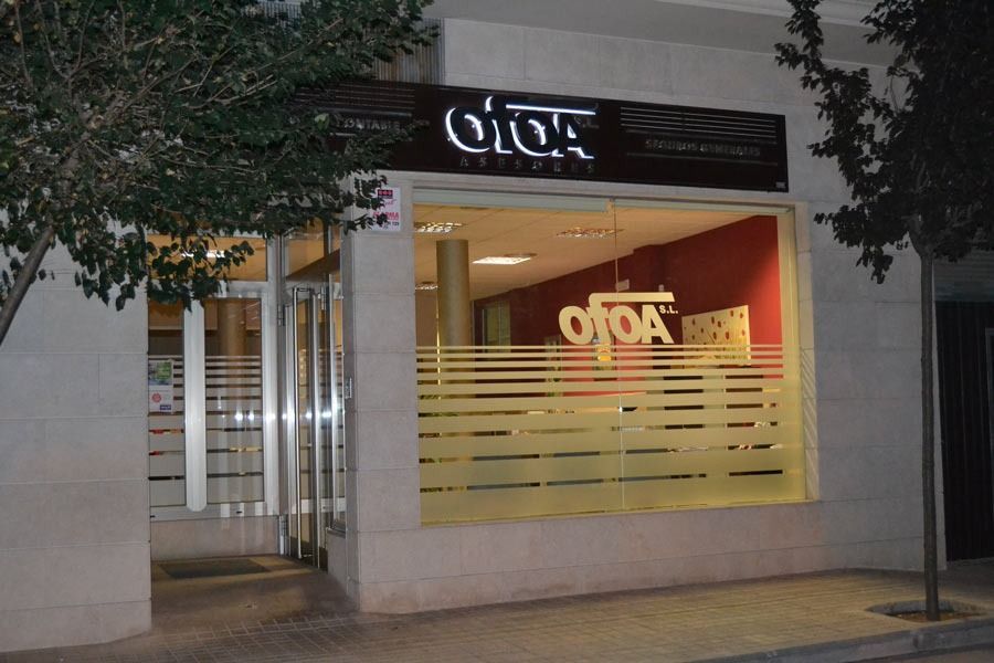 Exterior del restaurante Otoa con cartel iluminado, ventanales y fachada beige.